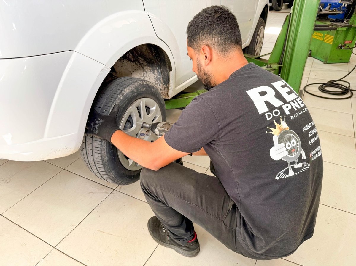Profissional da Rei do Pneu realiza troca de pneu com equipamento especializado